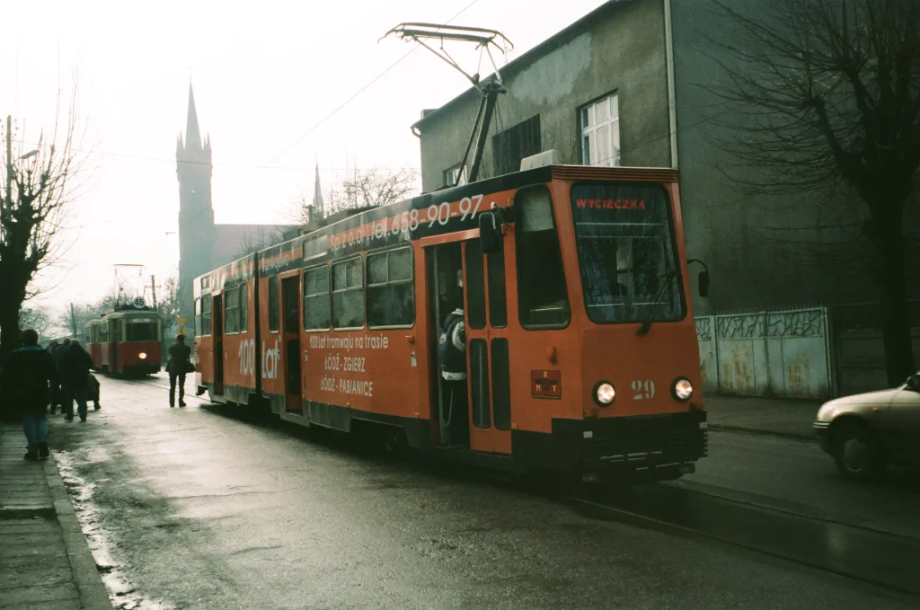 Tramwaj 803N numer 29 z tablicą WYCIECZKA podczas obchodów 100-lecia tramwajów podmiejskich, z zabytkowym tramwajem linii 45 w tle.